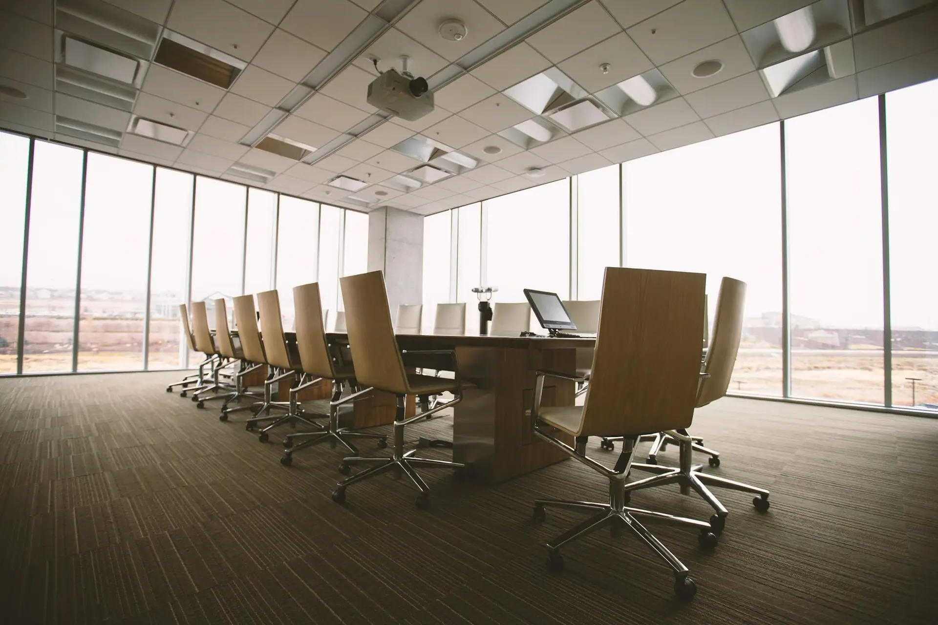 Empty boardroom with a long conference table and city views